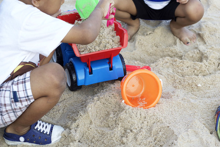 Children playing toy on sandの写真素材