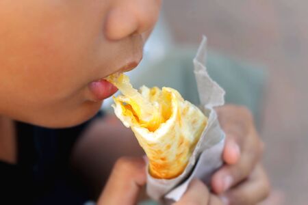The boy eating Indian Chapati Breads or roti dough.の写真素材