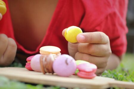 Kid eating french macaroons is deliciousの写真素材