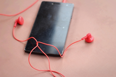 Smart phone with red earphoneの写真素材