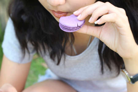 Woman eating french macaroons is deliciousの写真素材