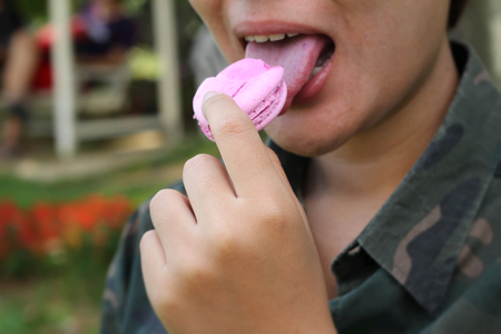 Men eating french macaroons is deliciousの写真素材