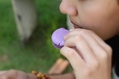 Woman eating french macaroons is deliciousの写真素材