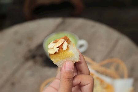 Toast topped with almonds and honey in handの写真素材