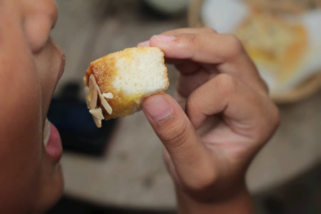 The boy eating toast topped with almonds and honey.