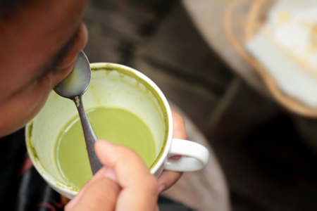 The boy is drinking green tea and milk.の写真素材