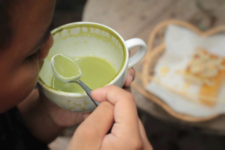 The boy is drinking green tea and milk.の写真素材