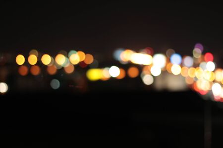 Blurred bokeh of car in city at nightの写真素材