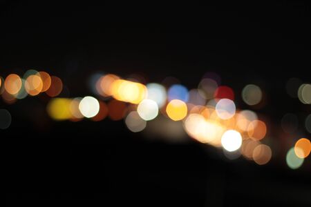 Blurred bokeh of car in city at nightの写真素材