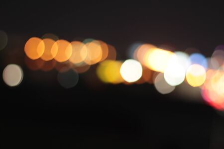 Blurred bokeh of car in city at nightの写真素材