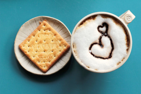 latte coffee with heart shape and biscuits.の写真素材