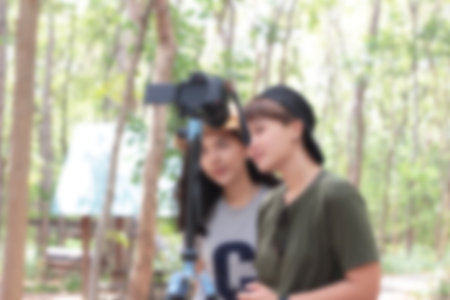 Blurred people using the camera at the park.