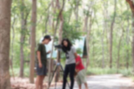 Blurred people using the camera at the park.の写真素材