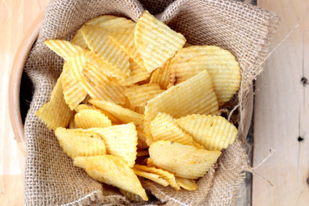 Potato chip on wood background