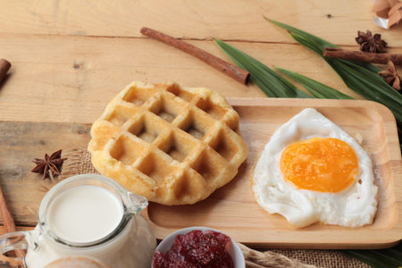 Sweet waffles and fresh milk with jam and egg heartの写真素材