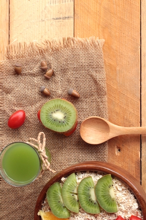 Oat flakes with fruit, kiwi, orange, tomato and kiwi juiceの写真素材