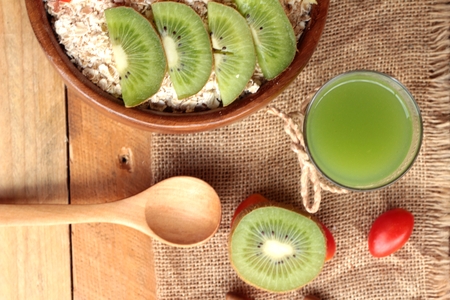 Oat flakes with fruit, kiwi, orange, tomato and kiwi juiceの写真素材