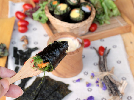 Vegetable salad wrapped with seaweed into spring rollsの写真素材
