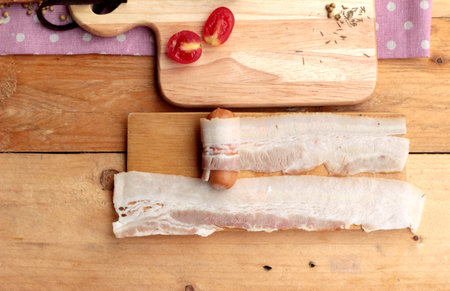 Sausages  wrapped in raw bacon fat at deliciousの写真素材