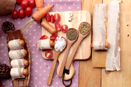 Sausages  wrapped in raw bacon fat at deliciousの写真素材