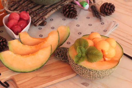Orange cantaloupe melon fruit juicy on wood backgroundの写真素材