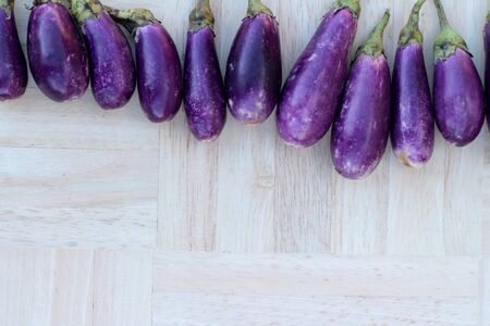 Purple eggplants fresh for cooking on wood backgroundの写真素材