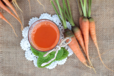 Fresh squeezed carrot juice and fresh carrotsの写真素材
