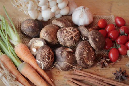 Mushrooms and vegetables on wood backgroundの写真素材