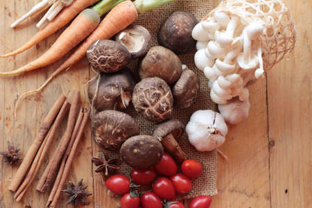 Mushrooms and vegetables on wood backgroundの写真素材