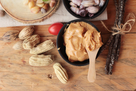 Peanut butter and peanut on wood background