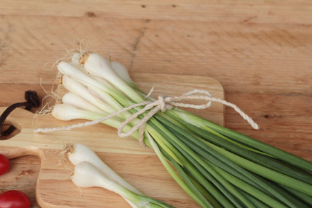 Fresh green onions on wood backgroundの写真素材