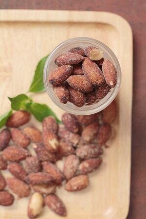 Almonds nuts with salt on wood backgroundの写真素材