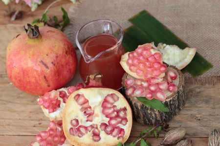 Ripe pomegranates with juice on wood backgroundの写真素材