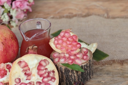 Ripe pomegranates with juice on wood backgroundの写真素材