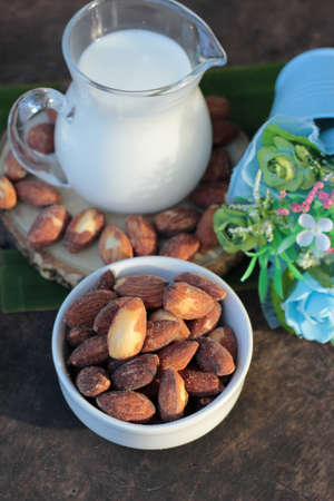 Almond milk with almond on wood backgroundの写真素材