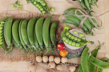 Fresh green peas pod on wood backgroundの写真素材