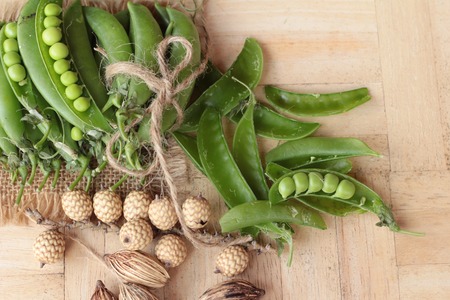 Fresh green peas pod on wood backgroundの写真素材