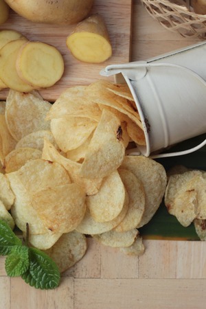 Crispy potato chips with salt and fresh potatoesの写真素材