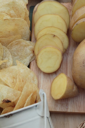 Crispy potato chips with salt and fresh potatoesの写真素材