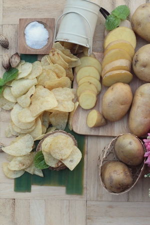 Crispy potato chips with salt and fresh potatoesの写真素材