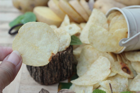 Crispy potato chips with salt and fresh potatoes