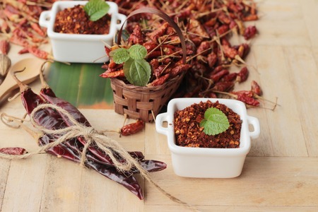 Chili powder and dried peppers on wood backgroundの写真素材