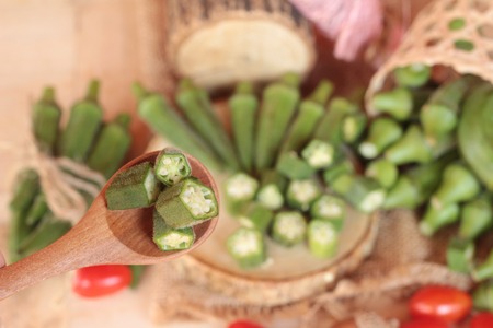Fresh okra pods and sliced on wood backgroundの写真素材
