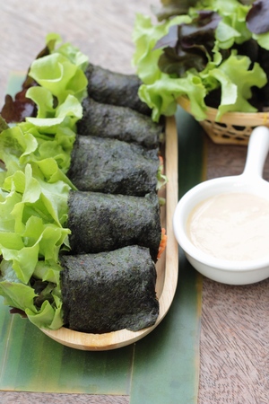 Fresh vegetable salad roll with seaweed and dressingの写真素材