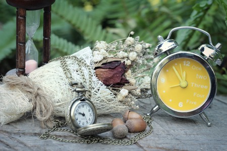 Antique pocket watch and hourglass with dried flowersの写真素材