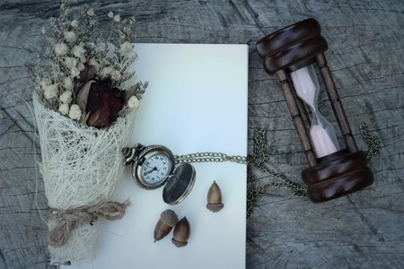Antique pocket watch and hourglass with dried flowersの写真素材