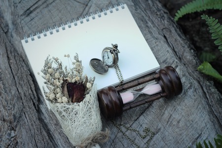 Antique pocket watch and hourglass with dried flowersの写真素材