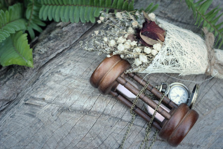 Antique pocket watch and hourglass with dried flowers