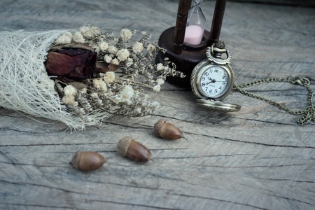 Antique pocket watch and hourglass with dried flowersの写真素材
