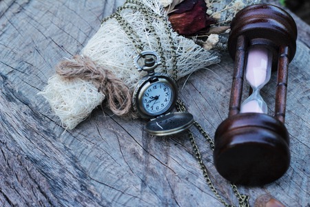 Antique pocket watch and hourglass with dried flowersの写真素材